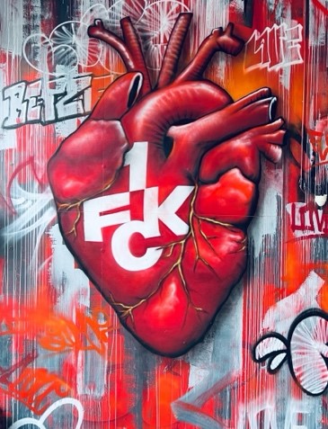 Ein Graffity eines Herzens mit FCK-Logo an eine Wand gesprüht.